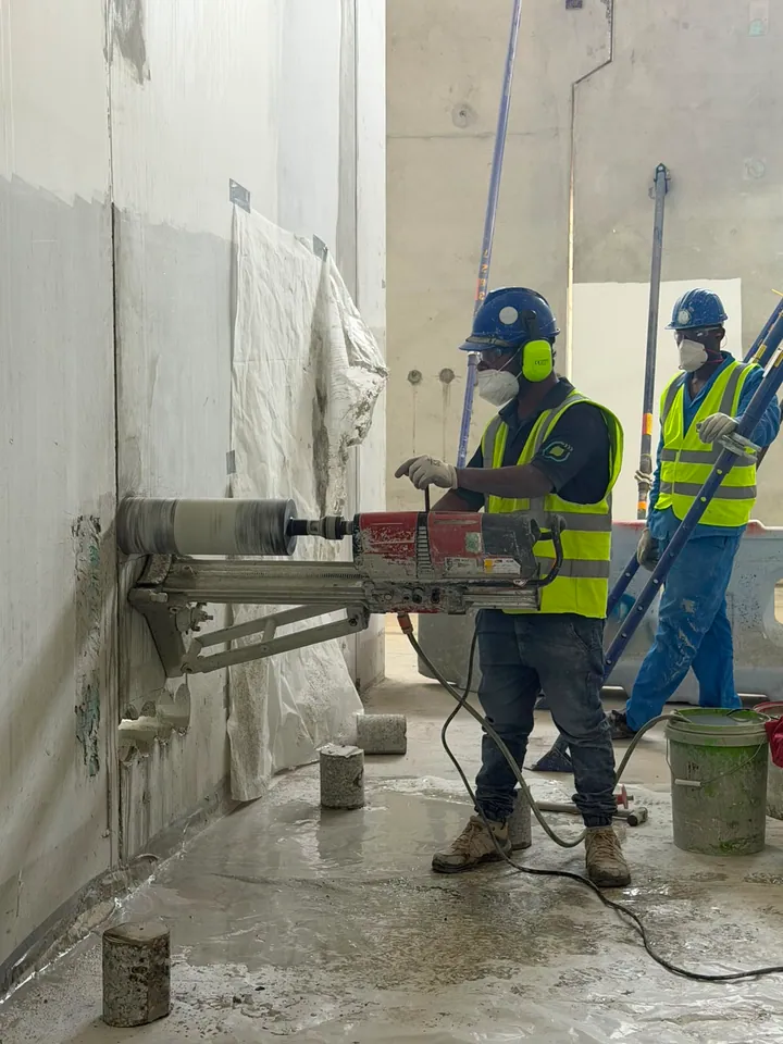Arasar team operating a horizontal core-drilling rig against a concrete wall