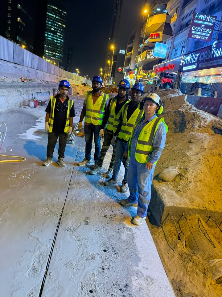 Arasar crew on a concrete work area beside an excavated trench at night